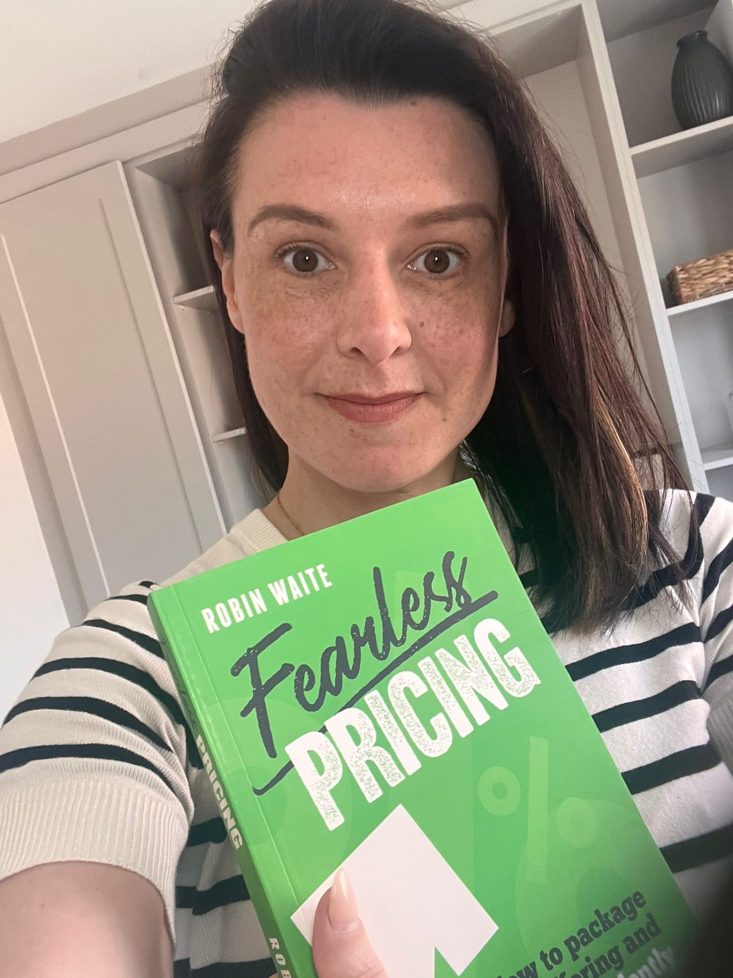 Katie Lyth holding Fearless Pricing by Robin Waite